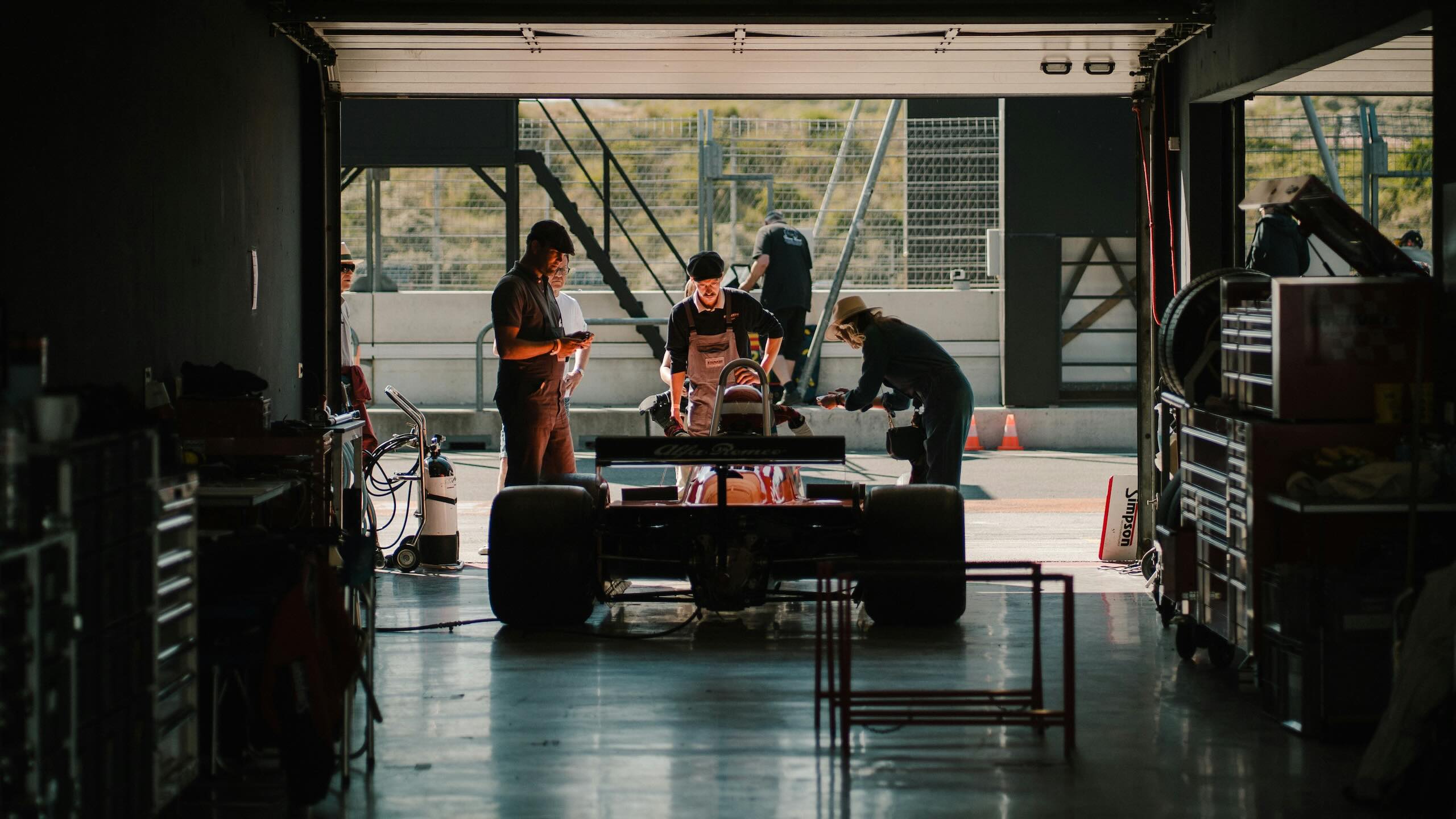 Motorsport engineering team working on a racing car inside a workshop