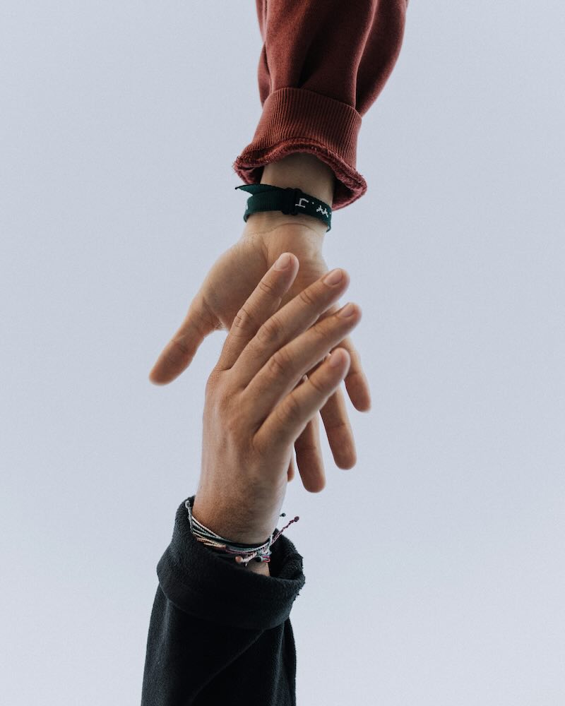 Helping hands reaching together to represent charity, support and community care