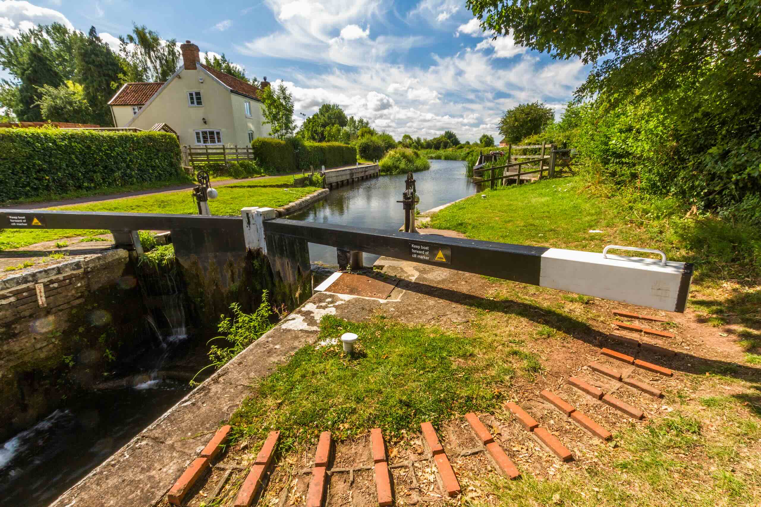 Canal lock beside a rural house in the Somerset countryside